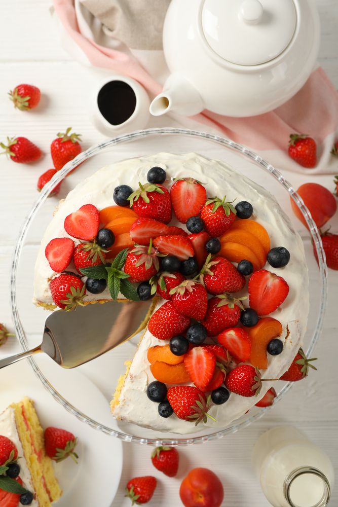 Composition with delicious berry cream cake on wooden table. Tasty dessert