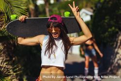 Attractive young woman with skateboard on summer vacation 56KDj4