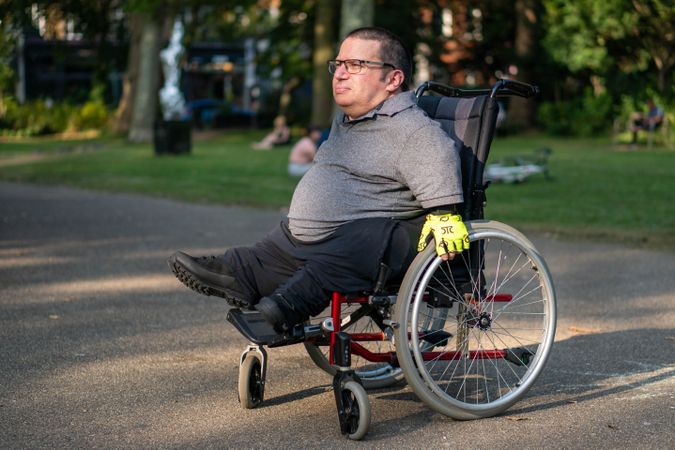 Portrait of man sitting in wheelchair in city park