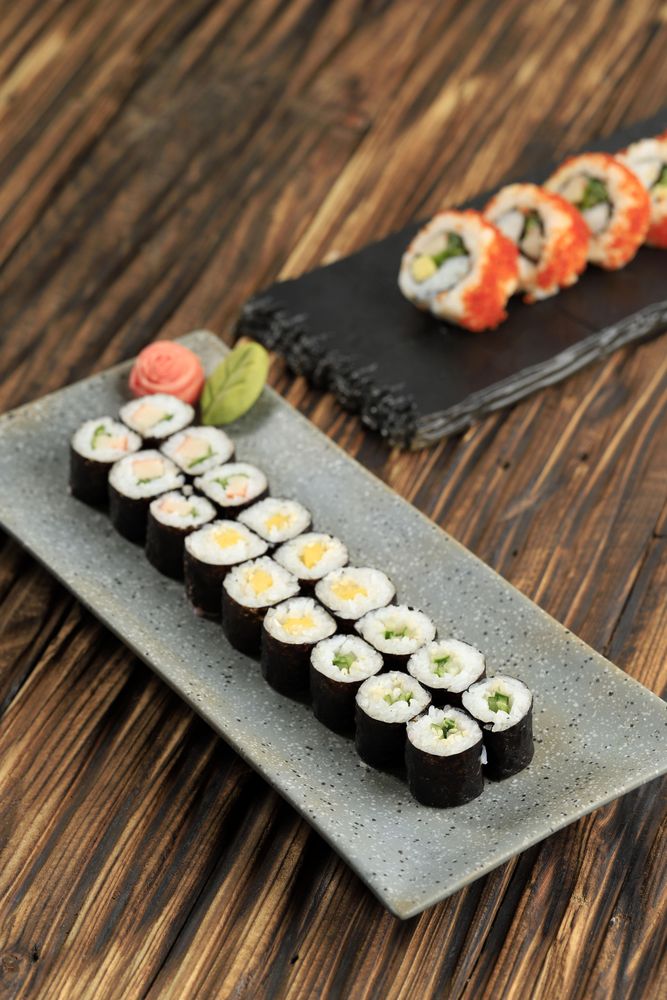Two long plates of sushi on table