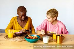 Two multi-ethnic females having breakfast together at home bGd8X0
