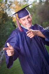Happy Male Graduate in Cap and Gown Outside.