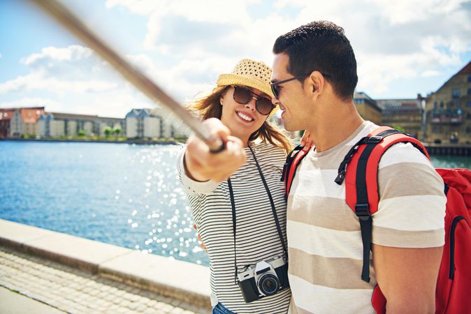 Woman holding selfie stick taking picture with her boyfriend
