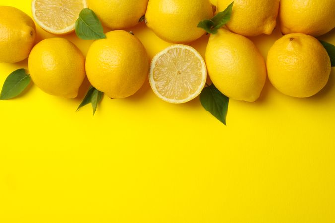 Lemons on yellow background, top view. Fresh fruit