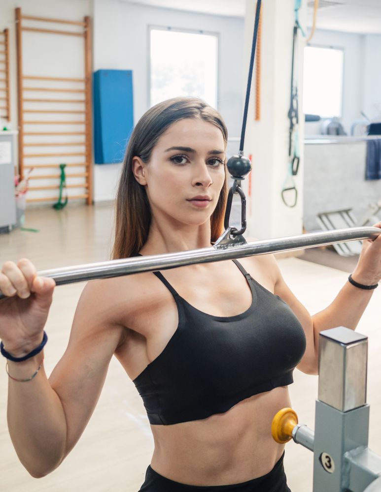 Fit woman doing lat pull-down exercise