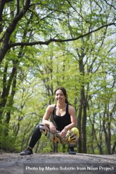Female crouching down in forest in athletic gear 41OXZ0