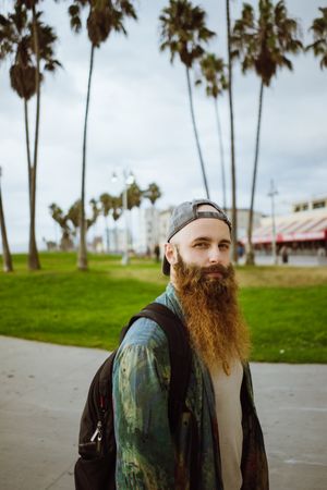 Bearded traveler on pavement in city