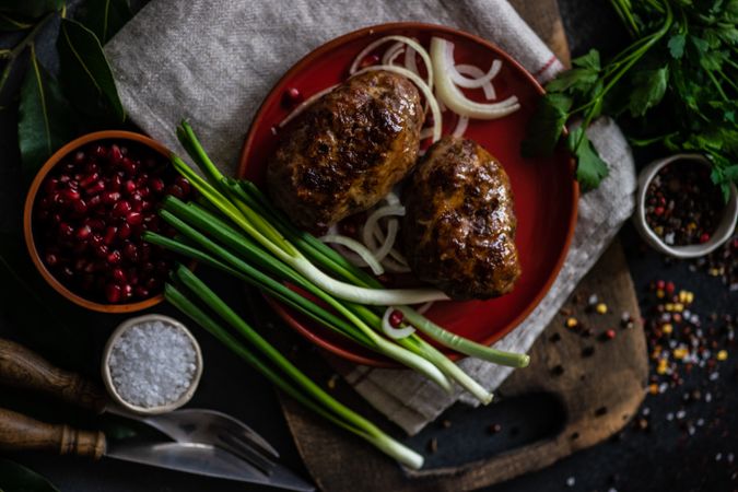 Top view of Georgian abkhazura meat cutlets on plate with spring onions