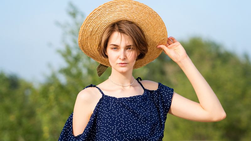 Young woman in straw hat outdoors