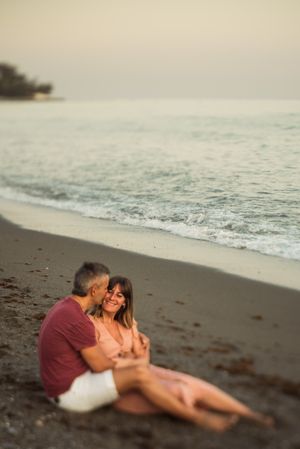 Delighted couple sitting on beach