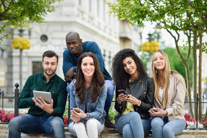 Women and men smiling and laughing in the street wearing casual clothes