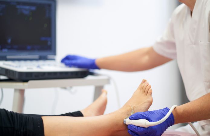 a physiotherapist performing an ultrasound on the ankle to check