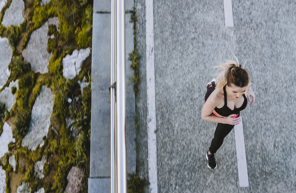 Woman running on embankment near water