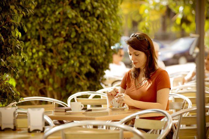 Adult female having tea in summer cafe