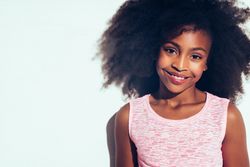 Studio portrait of young girl smiling in pink vest