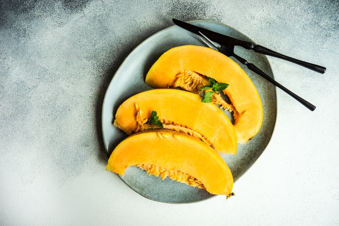 Slices of orange melon laid on plate with space for text