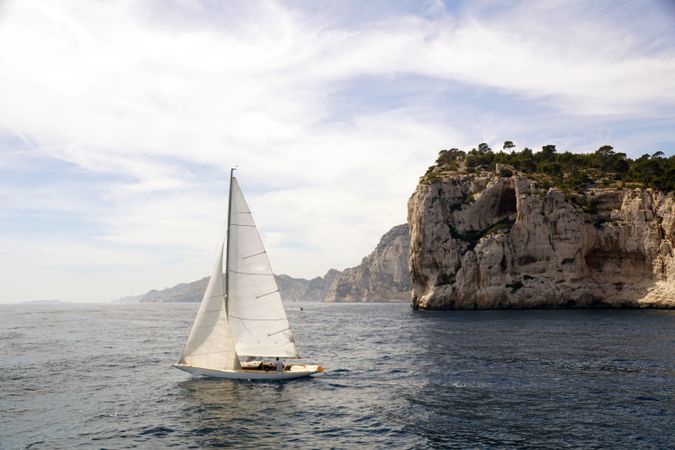 sailboat in sea and beautiful rocks
