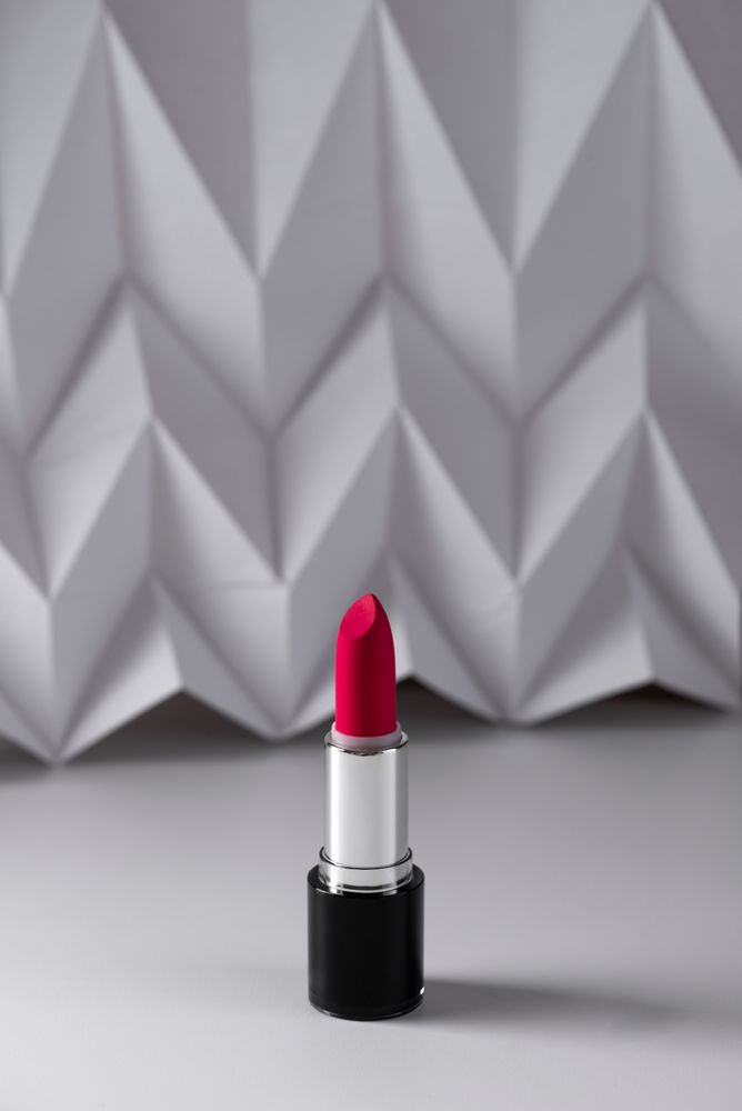 Pink lipstick on raised chevron. Product and make up contemporary concept
