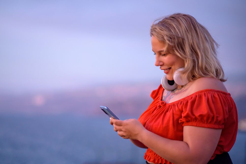 Cheerful body positive woman using smartphone