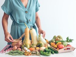 Anonymous woman with pile of fresh vegetables