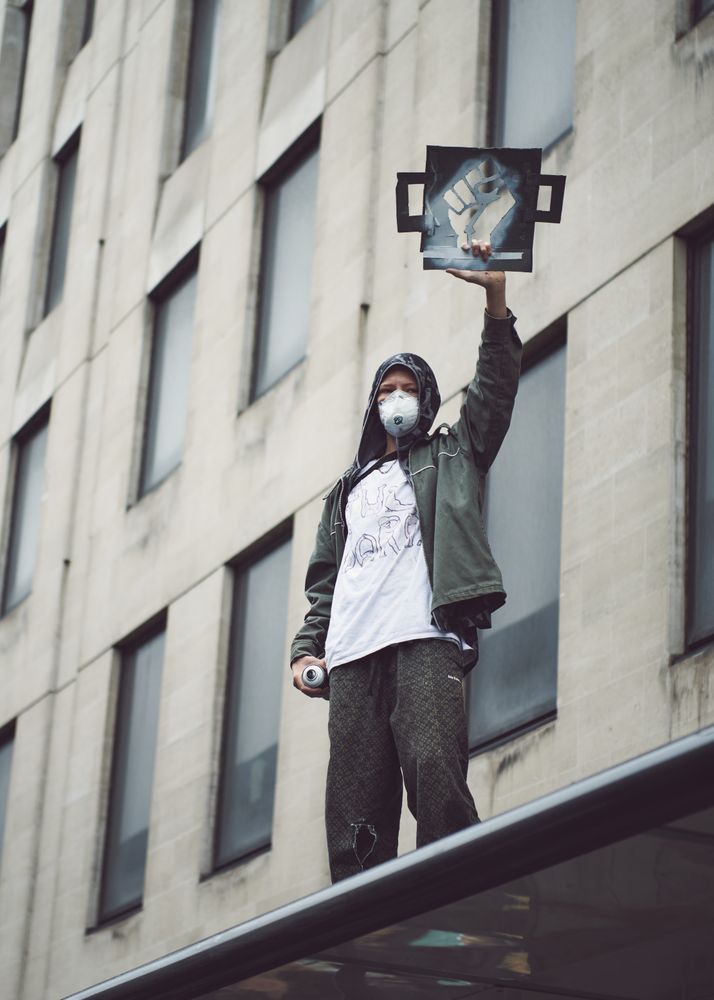 London, England, United Kingdom - June 6th, 2020: Man holds stencil of raised fist and spray can
