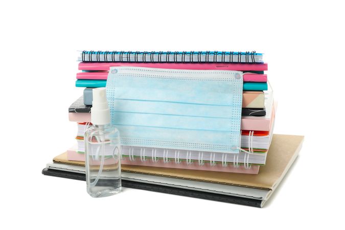 School supplies with medical mask and sanitizer isolated on plain background