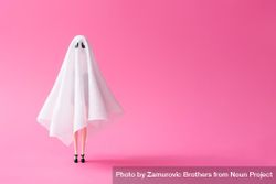 Doll under ghost sheet costume against pastel pink background 41aML4