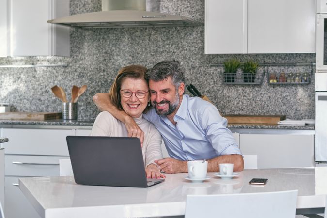 Mother and son having fun while watching video on laptop