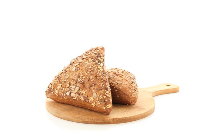 Triangular buns on cutting board isolated on plain background. Bakery products