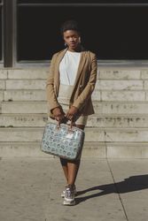 Stylish Black woman with handbag near steps on street