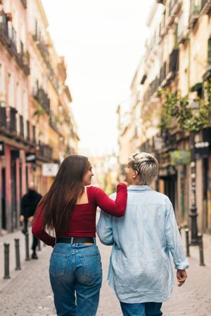 back view of two women walking on a street