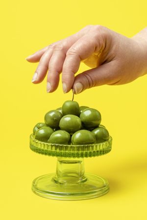 Woman hand taking a green olive