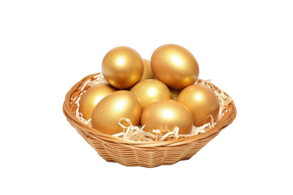 Concept of wealth and retirement - golden eggs, isolated on light background