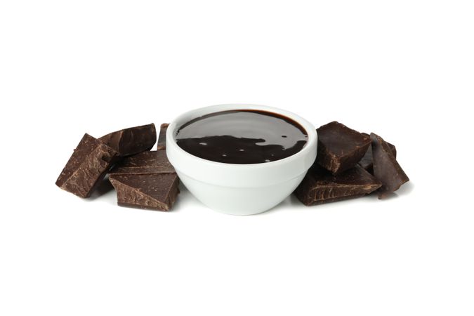 Melted chocolate and chocolate pieces isolated on blank background