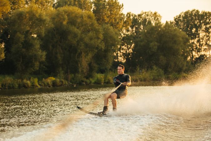 Focused male practicing water sports on large lake