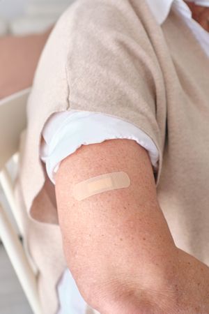 Crop woman with adhesive bandage on arm