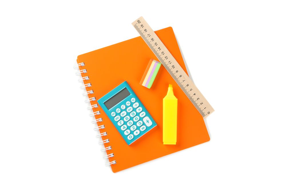 Orange notebook with stationary on table
