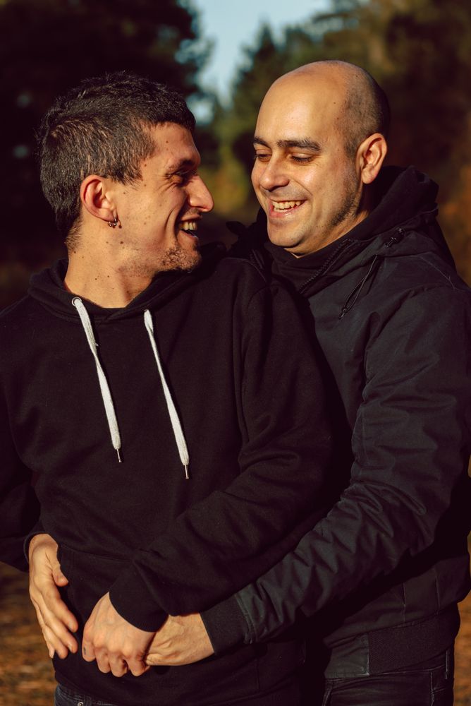 Smiling men hugging on path in park