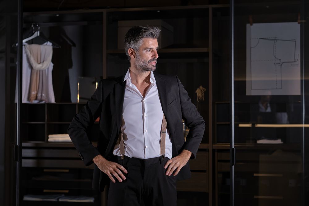 Mature businessman in suit standing at home