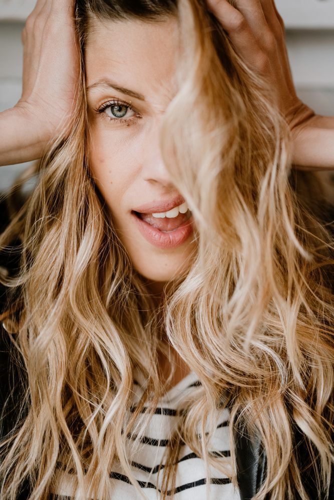 Woman clutching head and looking at camera