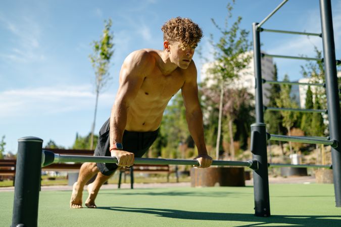 Strong young sportsman doing calisthenics