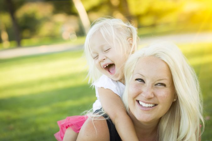 Mother and Little Girl Having Fun Together in Grass