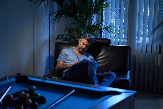 Concentrated office worker writing in papers at night
