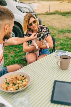 Male and female sitting at table outside with cute dog