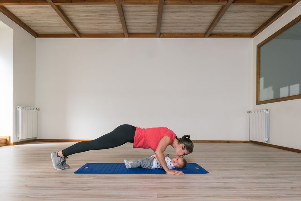 Mother exercising with baby in gym