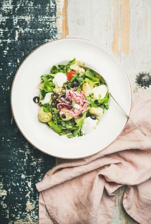 Top view of artichoke salad, on navy painted wooden background on linen napkin, vertical composition