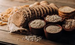 Wholegrain food pasta and freshly baked rye bread on table