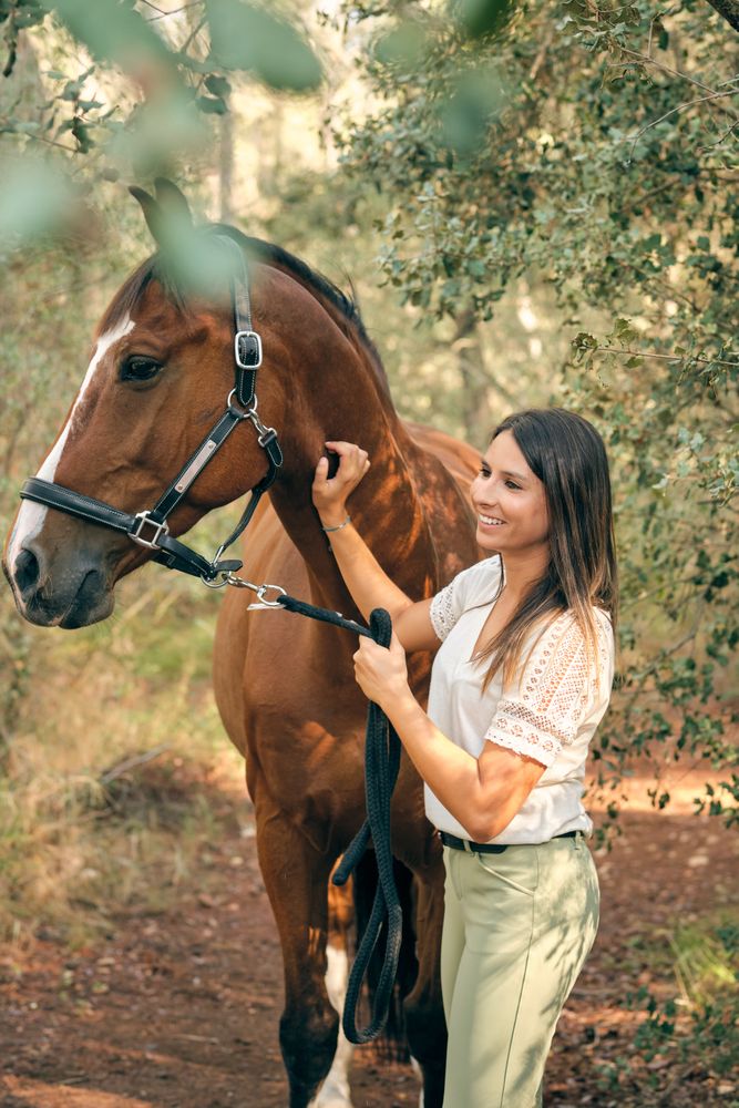 Happy woman with horse in woods