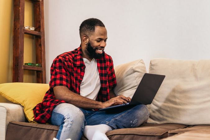 Black man teleworking with laptop from home