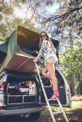 Woman standing in ladder opening car tent